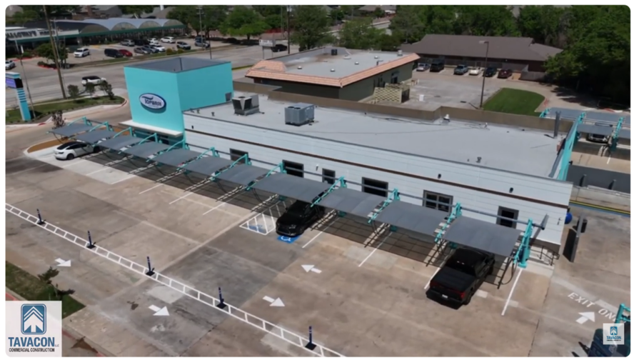 Aerial view of a completed express car wash facility featuring covered vacuum stations, parking areas, and a modern commercial building.